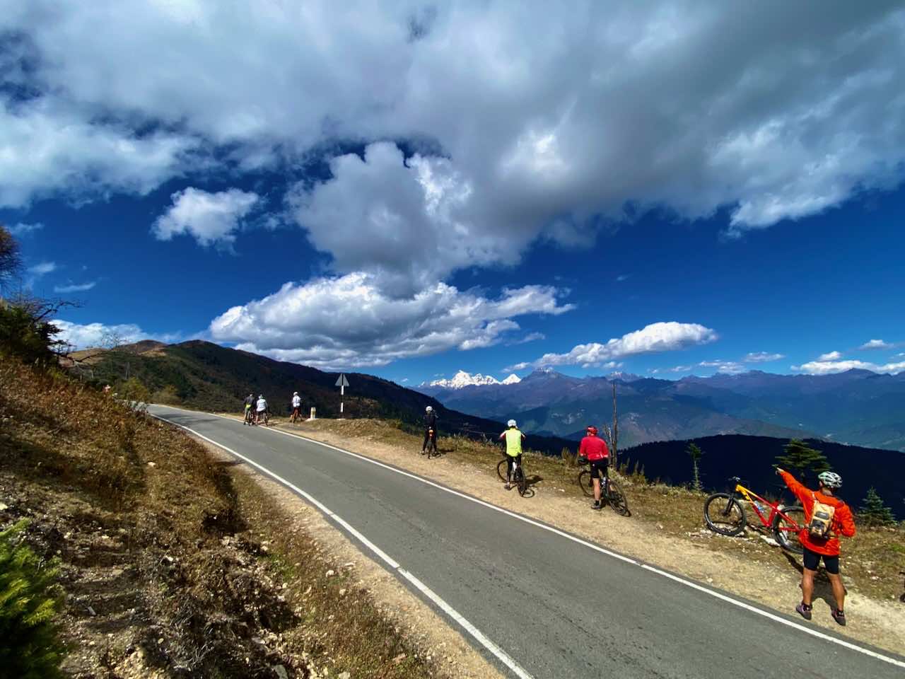 Cyclists admire the view whilst climbing the Chela La pass in Bhutan