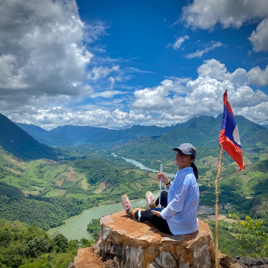 A lady sitting on top of the view point overlooking Nong Kiaw in Laos