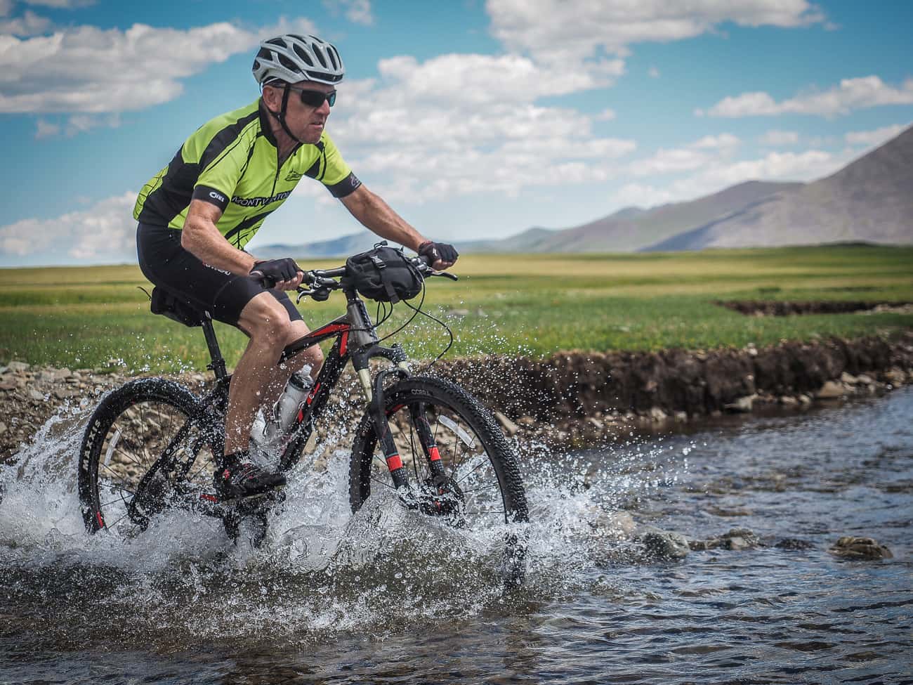 a cyclist in mongolia crossing a river