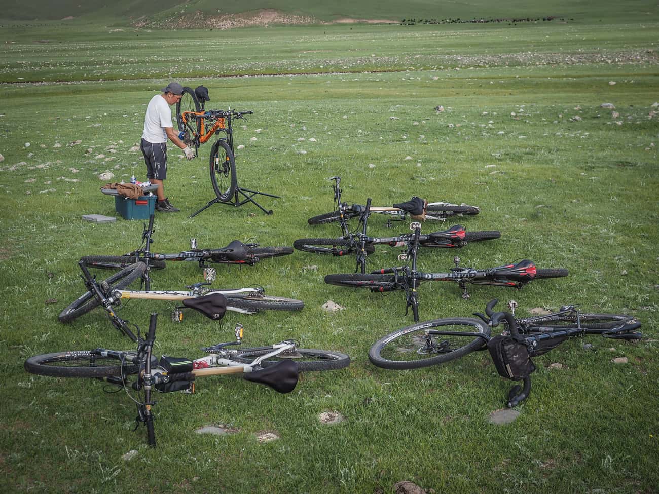 a bicycle mechanic working on bikes whilst camping in mongolia