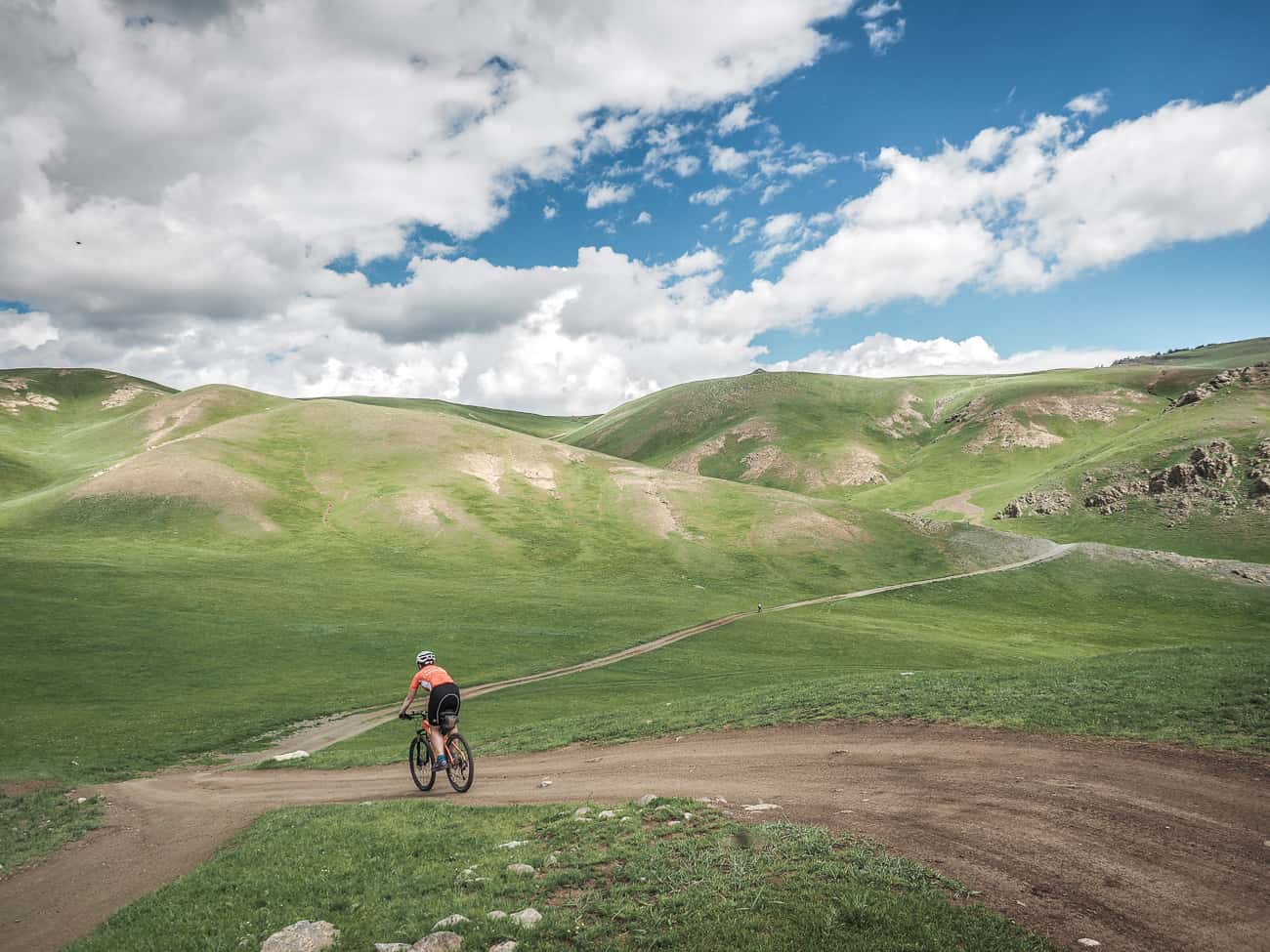a cyclist on a hilly gravel road in Mongolia