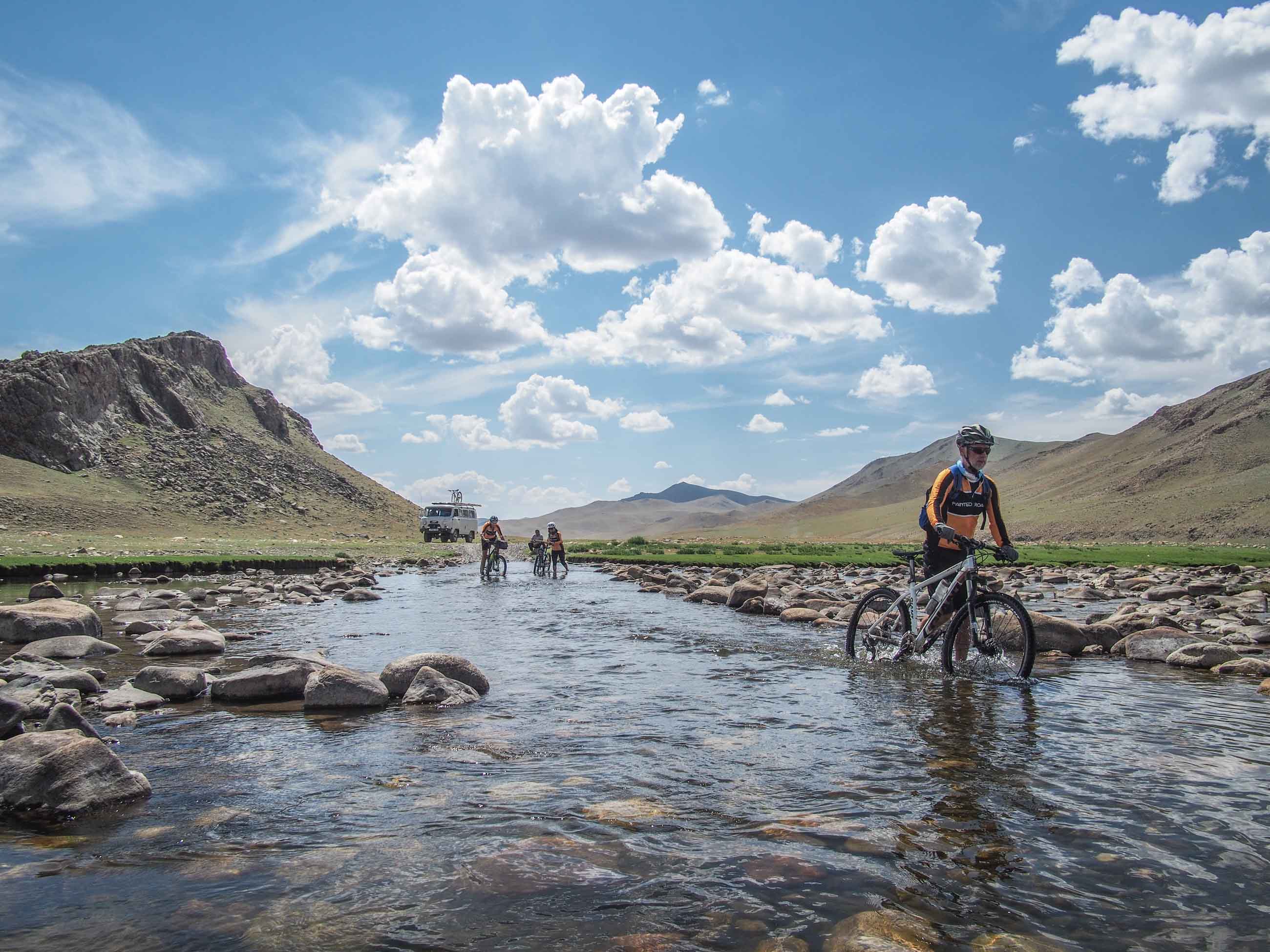 cyclists crossing a river in Mongolia